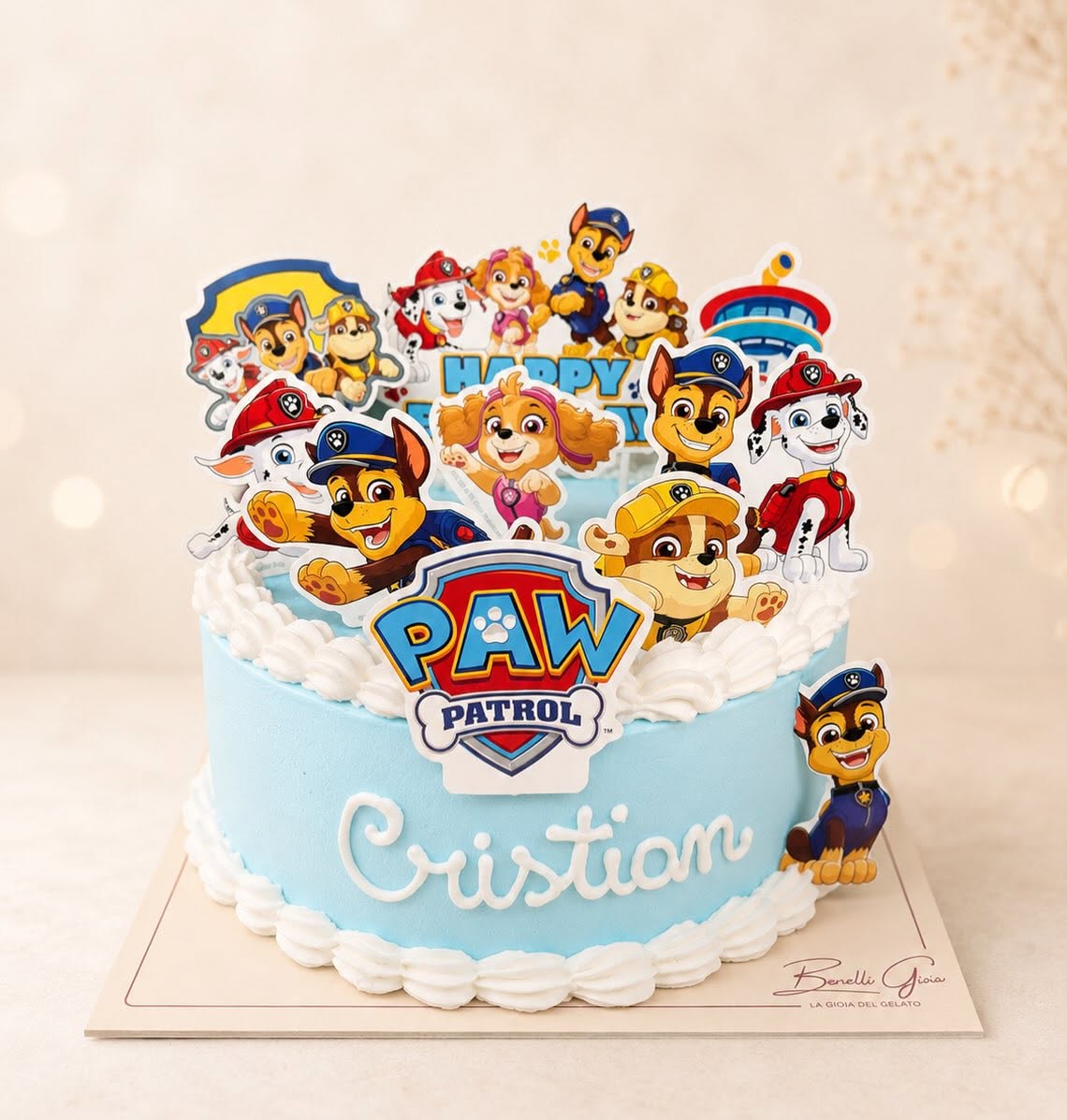 Torta di compleanno con panna azzurra, personaggi dei Paw Patrol e il nome Cristian